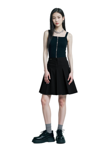 Woman wearing a black sleeveless top and black skirt with platform shoes on a white background
