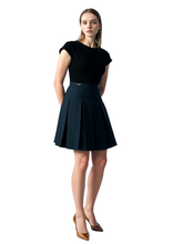 Woman wearing a black top and black skirt on a white background