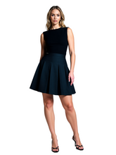 Woman wearing a black sleeveless dress on a gray background