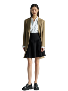 Woman wearing a beige blazer, white shirt, and black skirt on a white background